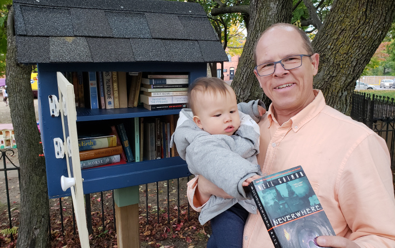 photo of Geoffrey Dow with Baobao returning Neverwhere to his local little library